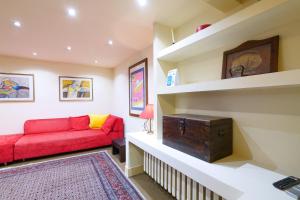 uma sala de estar com um sofá vermelho e prateleiras em PrimoPiano - Rasori em Milão