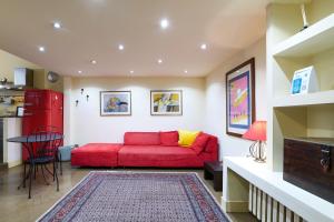 uma sala de estar com um sofá vermelho e uma mesa em PrimoPiano - Rasori em Milão