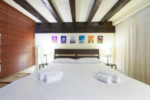 um quarto com uma grande cama branca e 2 almofadas em PrimoPiano - Rasori em Milão