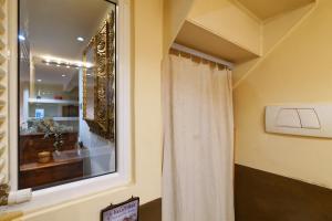 uma casa de banho com uma cortina de chuveiro e uma janela em PrimoPiano - Rasori em Milão