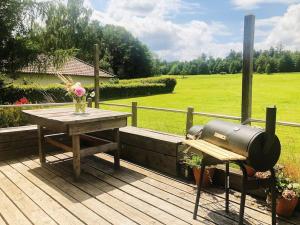 una parrilla y una mesa de picnic en una terraza de madera en Gästehaus im Garten en Zeitlofs