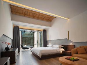 una camera d'albergo con letto e divano di 雾里观阵山 Foggy Valley a Zhangjiajie