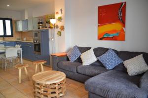 a living room with a couch and a kitchen at Oasis Famara a 20 m de la playa in Famara +65 photos