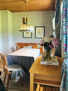 Un dormitorio con una cama y una mesa con un jarrón de flores en Gästehaus im Garten en Zeitlofs