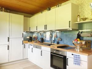 uma cozinha com armários brancos e uma tigela de fruta no balcão em Gästehaus im Garten em Zeitlofs