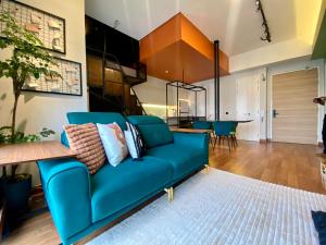 a living room with a blue couch and a dining room at Sentral Suites By RKD HOME in Kuala Lumpur