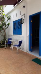 een patio met 2 stoelen, een tafel en een blauwe deur bij Wayang BnB in Yogyakarta