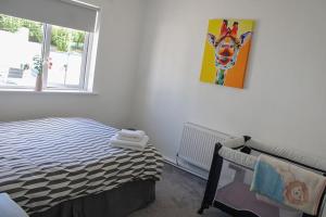 a bedroom with a bed with a painting of a cow on the wall at 2 BEDROOM The White House in Cahersiveen