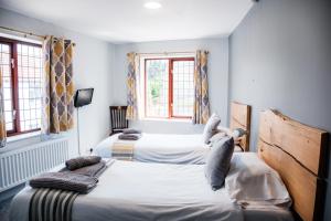 a bedroom with two beds and two windows at Mullions 51 B&B in Street