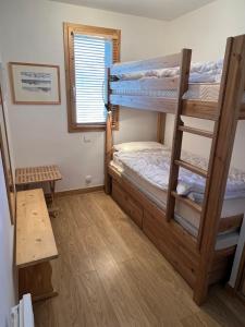 a room with two bunk beds and a table at Les Granges 13 6-8 person in Aime-La Plagne