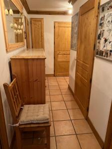 a small kitchen with a chair and a refrigerator at Les Granges 13 6-8 person in Aime-La Plagne