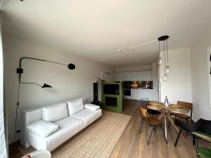 sala de estar con sofá blanco y mesa en MOKA Living eWald - 2Zi Apartment-FeWo, E-Charger, Barrierearm, Boxspring, TV en Borkheide