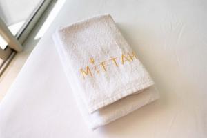 a white towel with the word mitzah on it at Appartement bord de mer +piscine in Tangier