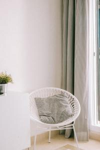 una silla blanca con una almohada en una habitación en Casa Jilou, en Mijas Costa