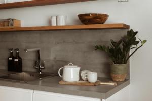 a kitchen counter with two cups and a sink at HIDEOUT Hotel in Hull