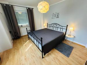 1 dormitorio con 1 cama negra en una habitación en Ferienwohnung Jule, en Grenzach-Wyhlen