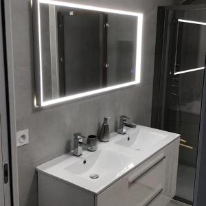 y baño con lavabo blanco y espejo. en Suite avec 2 chambres d'hôtes pour 1 à 4 personnes avec terrasse, vue mer, parking privé, proche port et aéroport, en Ajaccio