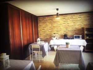 un comedor con 2 mesas y una pared de ladrillo en Casa Ángel 1982, en Oia