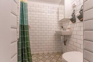 a bathroom with a green shower curtain and a sink at Wagner eState FEEL THE OLD TOWN VIBE in Braşov