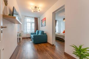 a living room with a blue chair and a bedroom at Wagner eState FEEL THE OLD TOWN VIBE in Braşov