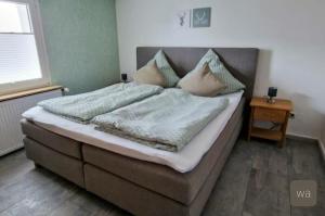 Un dormitorio con una cama grande con almohadas. en Ferienwohnung Ahlemeier, 