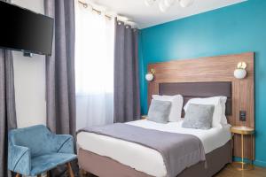 a bedroom with a bed and a blue wall at The Originals Boutique, Hôtel Le Marignan,Le Havre Centre Gare in Le Havre
