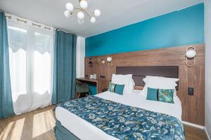 a bedroom with a large bed and a blue wall at The Originals Boutique, Hôtel Le Marignan,Le Havre Centre Gare in Le Havre +21 photos