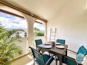 een eetkamer met een tafel en stoelen op een balkon bij Bulle des Roches Noires - 5min de la Plage des Roches Noires - T2 bis - 50m² in Saint-Paul