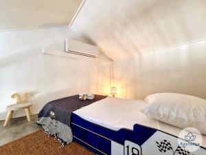 een kleine kamer met een bed en een stoel bij Bulle des Roches Noires - 5min de la Plage des Roches Noires - T2 bis - 50m² in Saint-Paul