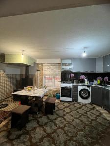 uma cozinha com uma mesa e uma cozinha com um fogão em Aruuzat 