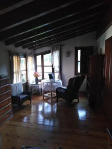 ein Wohnzimmer mit Stühlen und einem Tisch mit einem Laptop in der Unterkunft casa Berastegui, experiencia rural en el cidacos in Enciso