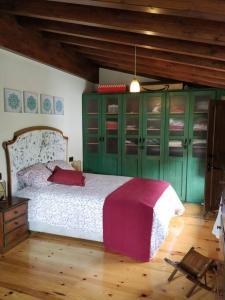 ein Schlafzimmer mit einem großen Bett und grünen Schränken in der Unterkunft casa Berastegui, experiencia rural en el cidacos in Enciso