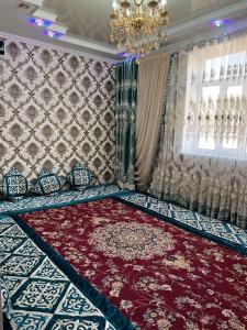 um quarto com um grande tapete vermelho e um lustre em Aruuzat 