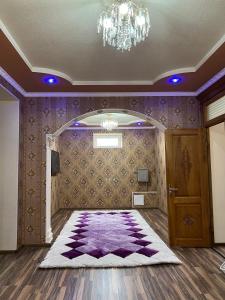 um quarto com um tapete roxo e um lustre em Aruuzat 