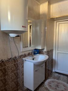 uma casa de banho com um lavatório branco e um espelho. em Aruuzat 