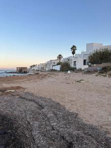 拉馬薩的住宿－Luxeux et Idéal à Marsa Plage vue sur Mer，白色建筑和海洋的沙滩