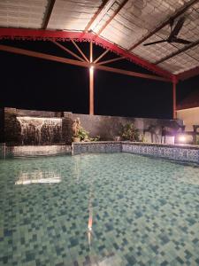uma grande piscina com queda de água em Param Country Home With Pool em Jalandhar