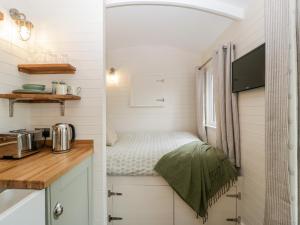 uma pequena cozinha com uma cama numa pequena casa em Hazel em Cirencester