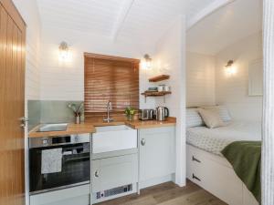 una cocina con fregadero y una cama en una habitación en Willow en Kemble