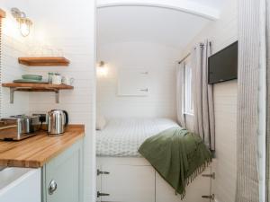 a small kitchen with a bed in a tiny house at Beech in Kemble