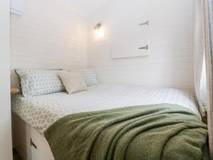 a small bed in a room with white walls at Beech in Kemble