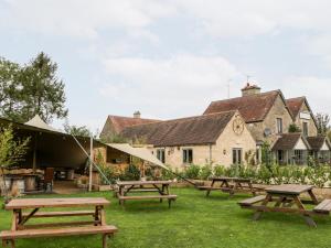 a group of picnic tables in front of a building at Beech in Kemble