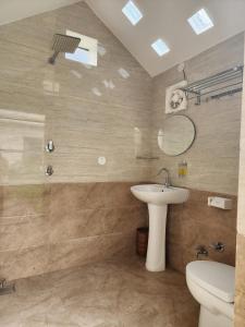 uma casa de banho com um lavatório, um WC e um espelho. em Param Country Home With Pool em Jalandhar