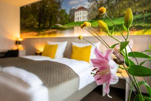 um quarto com uma cama e uma flor no primeiro plano em Hotel Restaurant Elbebrücke em Oranienbaum-Wörlitz