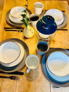 a wooden table with plates and utensils on it at Kåseberga Hideout in Kåseberga