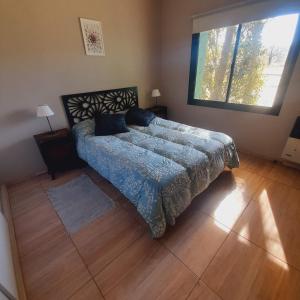 a bedroom with a bed and a large window at Los Bambues Cabañas in El Volcán