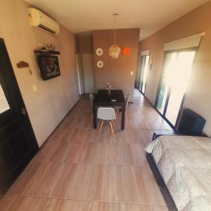 a room with a table and a bedroom with a bed at Los Bambues Cabañas in El Volcán