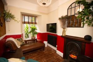 a living room with a couch and a fireplace at The Baby Grand- Quirky & Compact in Torquay