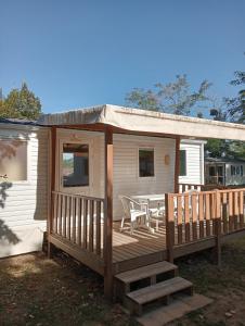 a cabin with a deck with a table on it at La Bastide in Mazères