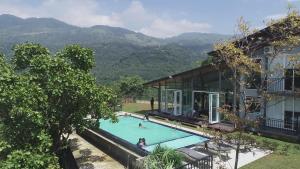 a swimming pool in front of a house with mountains in the background at Cinnamon Serenity Villa in Badulla